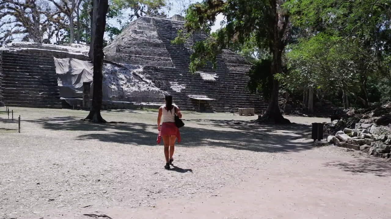 una mujer turista solitaria se acerca a la pirámide del templo en las antiguas ruinas mayas