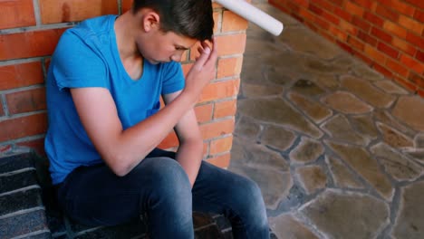 Sad-schoolboy-sitting-alone-on-staircase