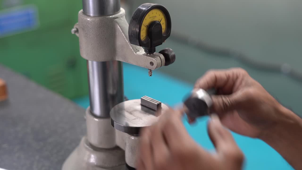 Asian man measuring Machining accuracy using a level gauge in Indian factory