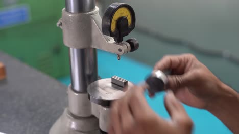 asian man measuring machining accuracy using a level gauge in indian factory