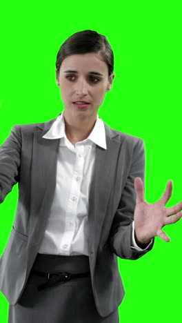 mujer de negocios haciendo gestos contra la pantalla verde
