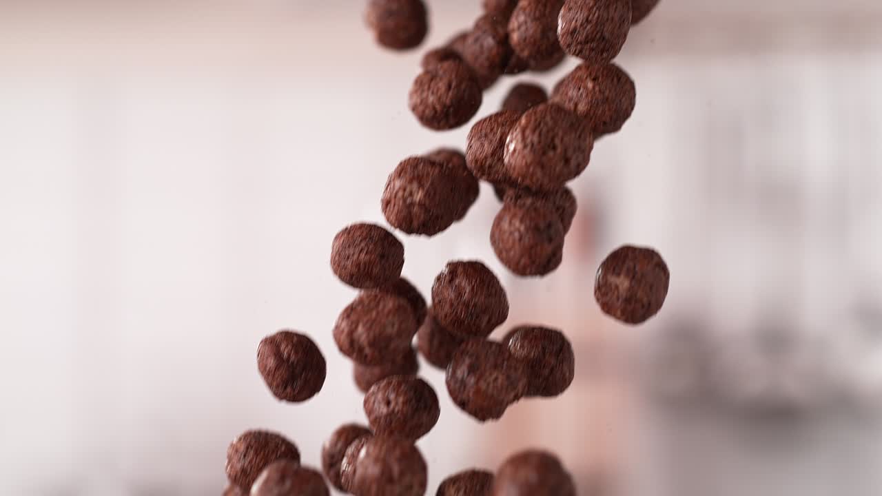 cereales en forma de bola de chocolate cayendo en un lote en cámara lenta y macro