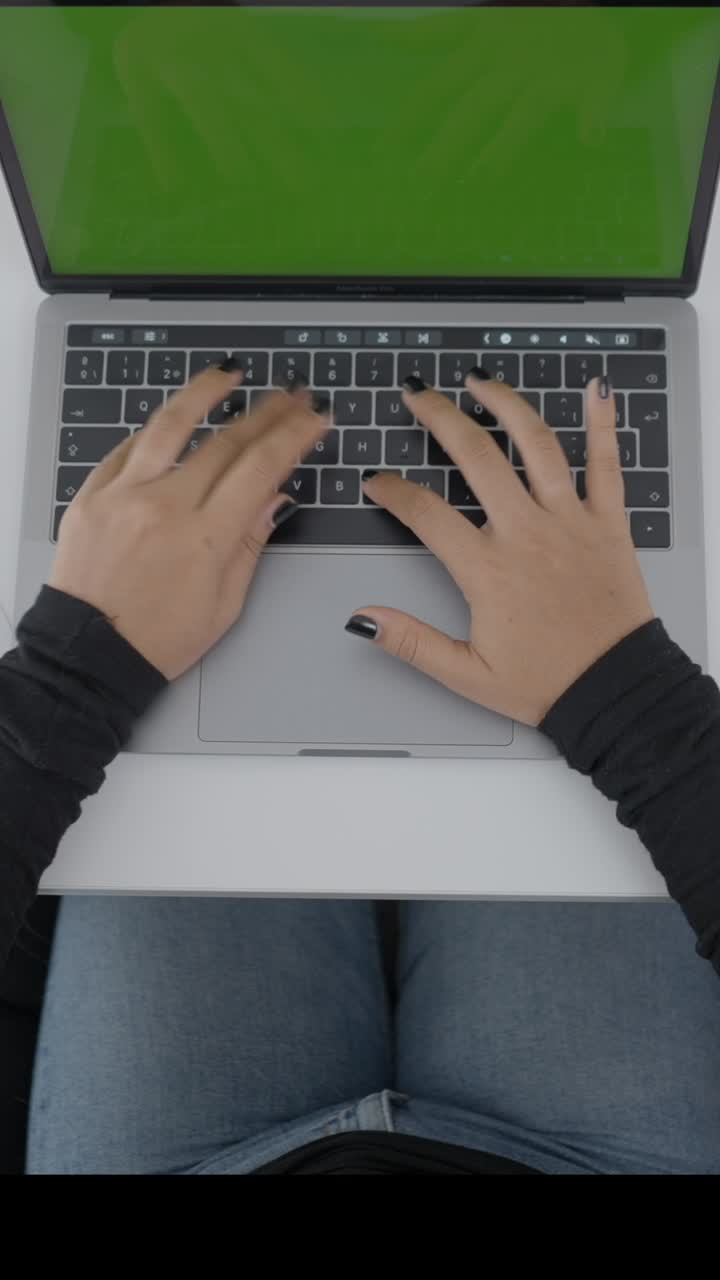 persona escribiendo en una computadora portátil con una pantalla verde