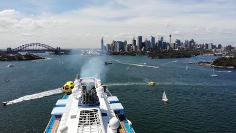 Toma-Aérea-De-Un-Crucero-En-El-Puerto-De-Sydney-Y-El-Horizonte-De-La-Ciudad