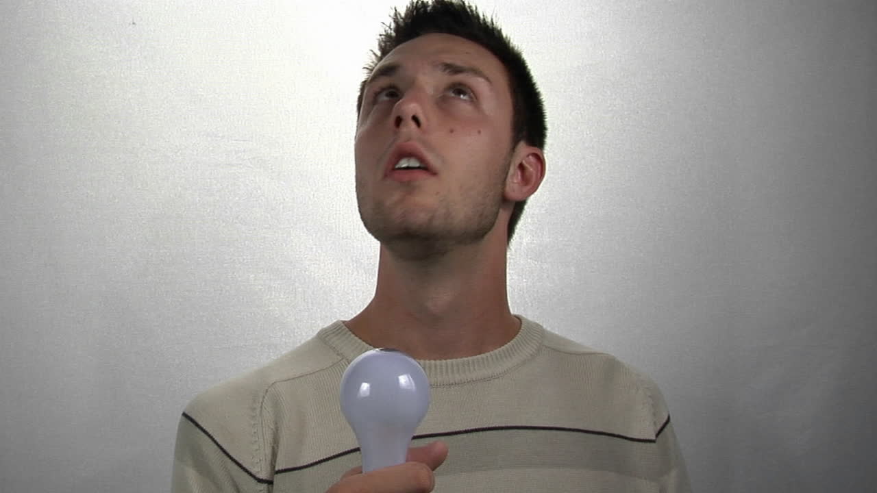 소형 형광 전구에 불이 들어오는 것을 바라보는 청년 1