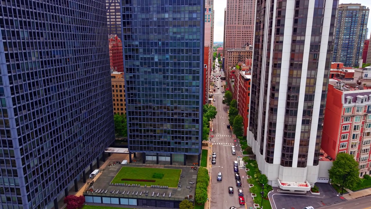 Canyon urbano tra i grattacieli, centro di Chicago, Illinois. Vista aerea di un viale rettilineo fiancheggiato da torri di vetro e mattoni, traffico e una terrazza sul tetto sottostante. Lake Shore Drive.