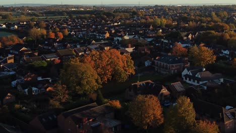 british neighbourhood housing aerial view looking down over early morning glowing sunrise autumn coloured rooftops