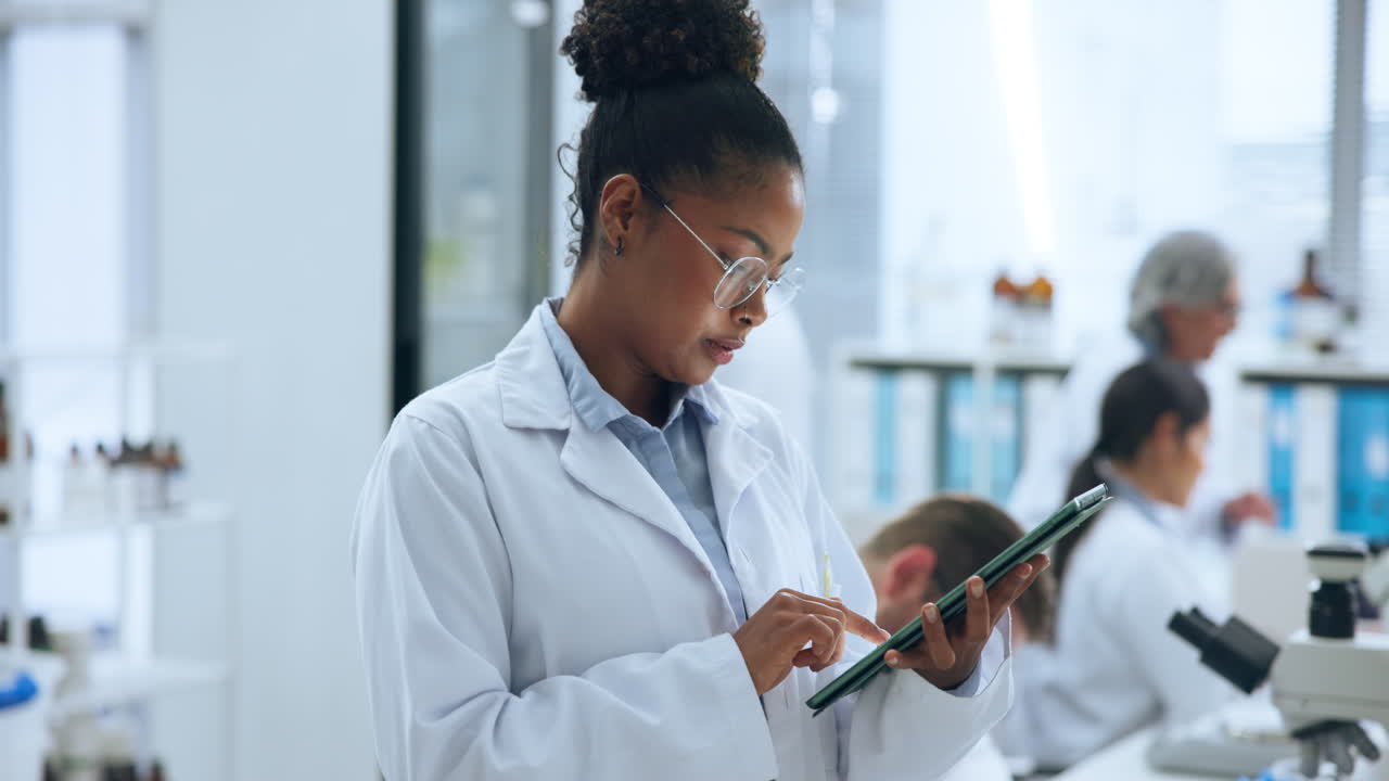 Scienziata concentrata che usa un tablet digitale in un laboratorio moderno