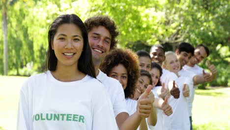 volunteers standing in a row giving thumbs up to camera