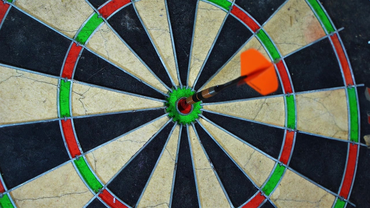 Slow Motion of dart hitting the bullseye on the dart board, precision and practice