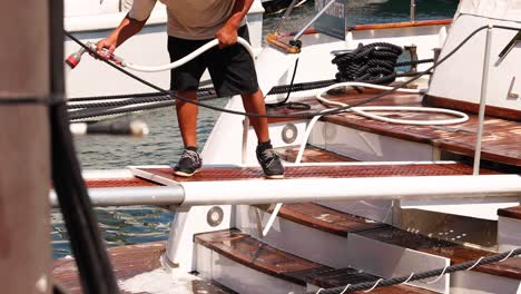 person cleaning boat with hose in monte carlo