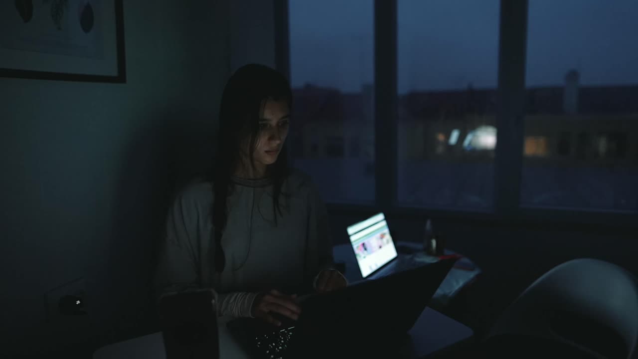 mujer trabajando en la computadora portátil por la noche