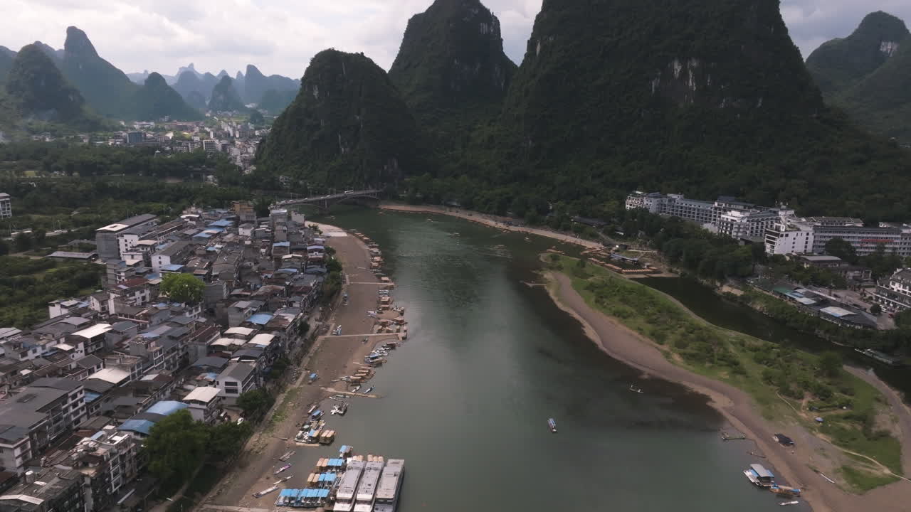 drone que se eleva a lo largo del río li en la ciudad de yangshuo, en la nublada guangxi, china