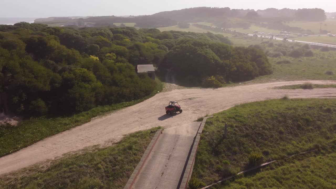 vehículo rojo inusual conduciendo por carretera sin pavimentar, chapadmalal en argentina