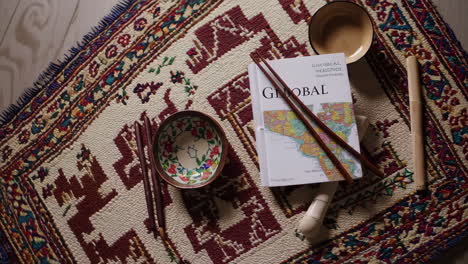 global book and asian decor on a rug