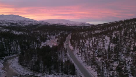 Tonos-Crepusculares-Sobre-El-Paisaje-Nevado-De-Noruega-Con-Un-Camión-Solitario-En-La-Carretera,-Vista-Aérea