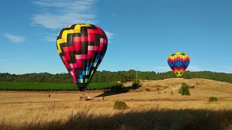 globo aerostático aterriza en el campo mientras se prepara para ser desinflado