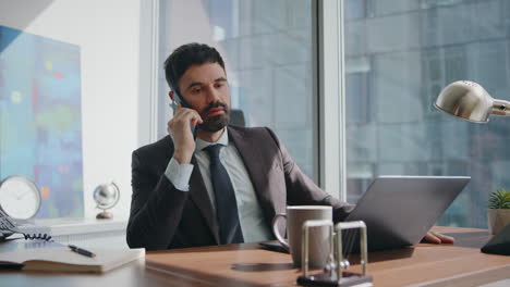 dissatisfied entrepreneur speaking smartphone nervously sitting office close up.
