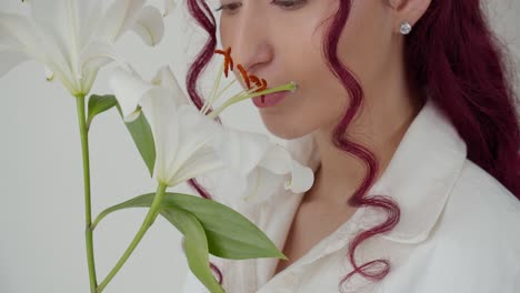 beautiful woman smelling fragrant white casablanca lilies, isolated in white background