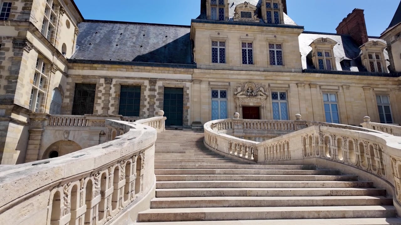 Vista della famosa Scalinata a Ferro di Cavallo che conduce al Castello di Fontainebleau, un simbolo della storia reale francese.
