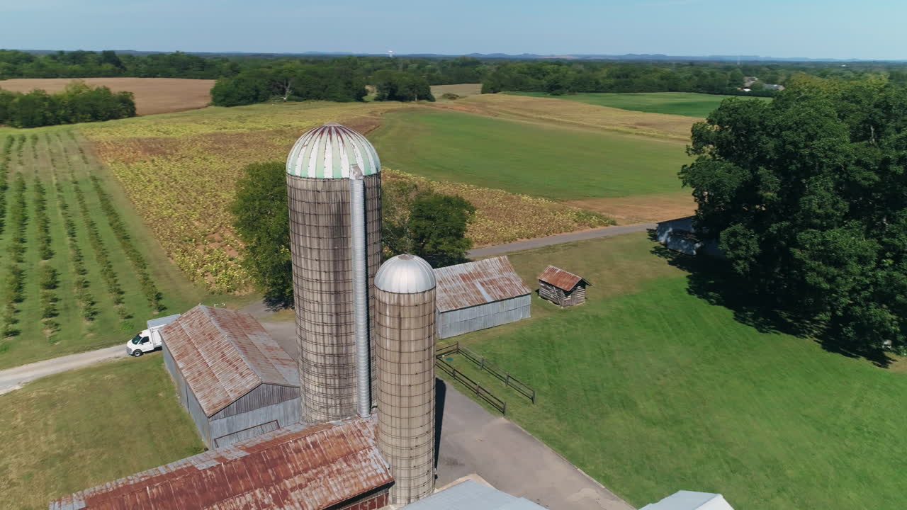 antena en órbita alrededor de silos de grano en la granja con carretera en el fondo, 4k
