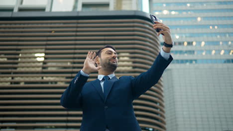 Hombre-De-Negocios-En-La-Gran-Ciudad-Sosteniendo-El-Teléfono,-Se-Despide-De-Alguien-En-Videollamada