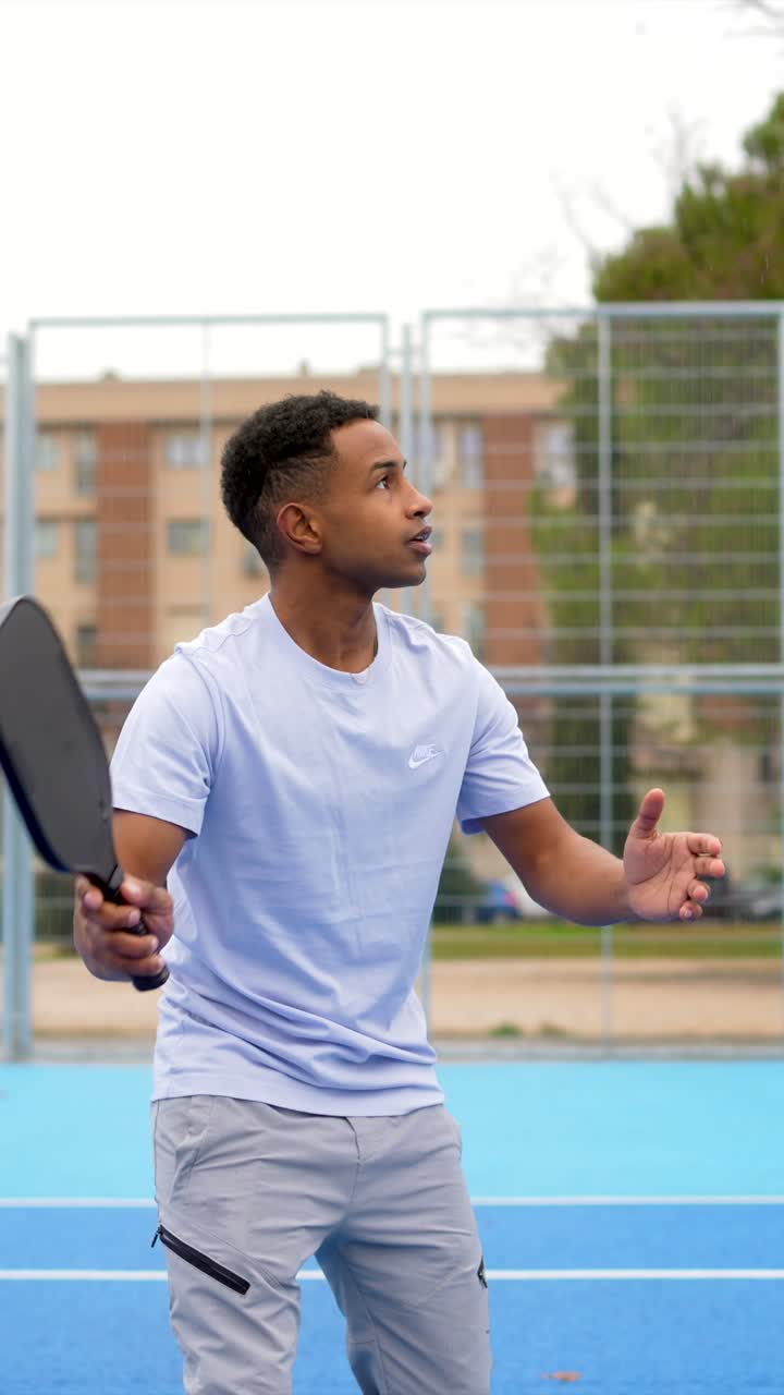 Young Man Playing Pickleball on an Outdoor Court