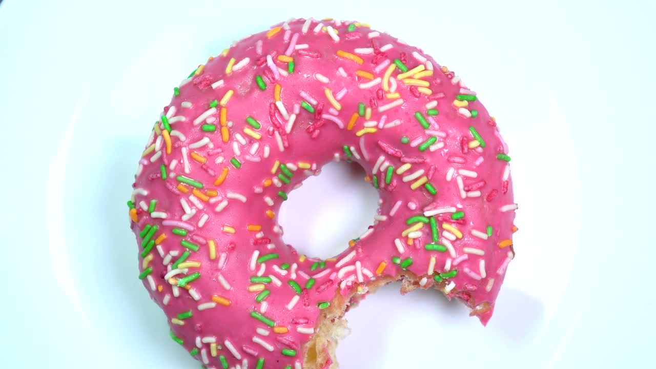 alguien mordió una rosquilla con salpicaduras. yummy girando rápido en un plato blanco.