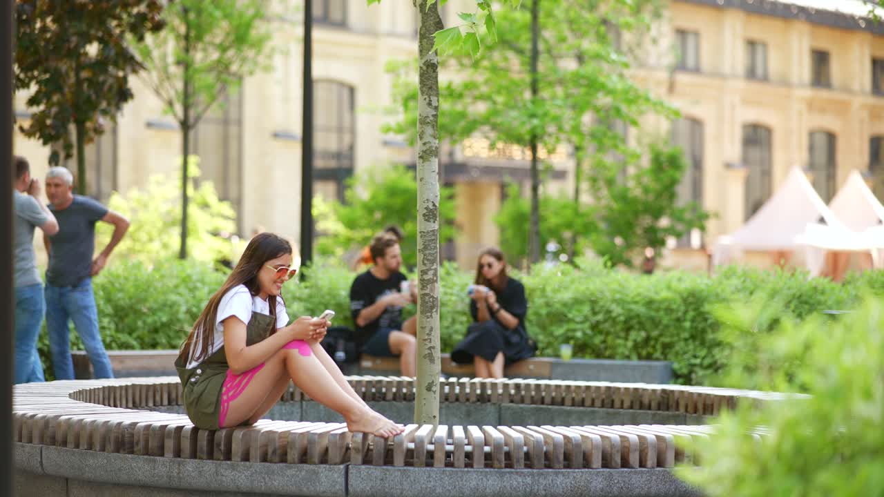 молодая женщина использует смартфон в городском парке