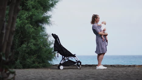 along the sea beach, the mother lifts her son with glee, adding an element of fun to their interaction. a happy young family enjoys their beach experience