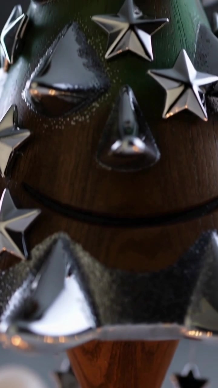 Vertical video: Pulling back camera revealing wooden cone tree ornament on shelf with silver charms