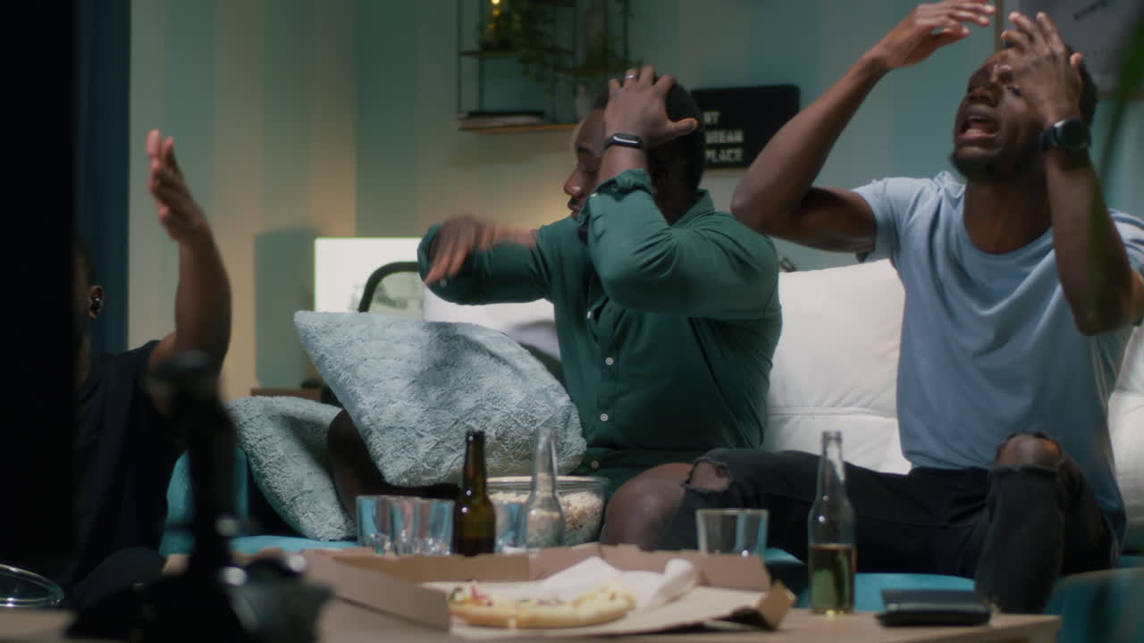 Friends Watching TV at Home with Food and Drinks