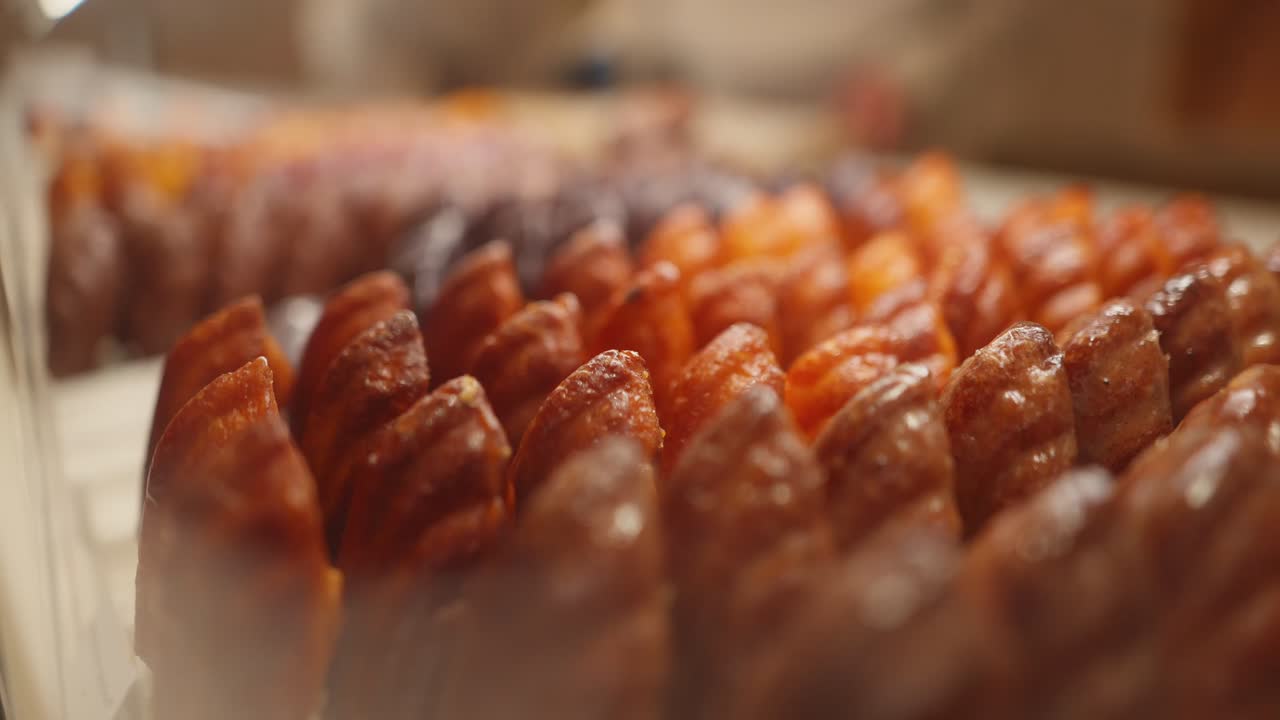 Close up view in slow motion of Madeleine pastries in a counter in a pastry shop in Paris