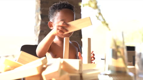 Small-South-African-boy-balancing-blocks-on-a-table