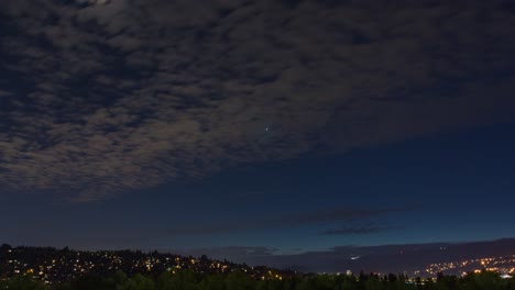moonlit night sky over city and forest