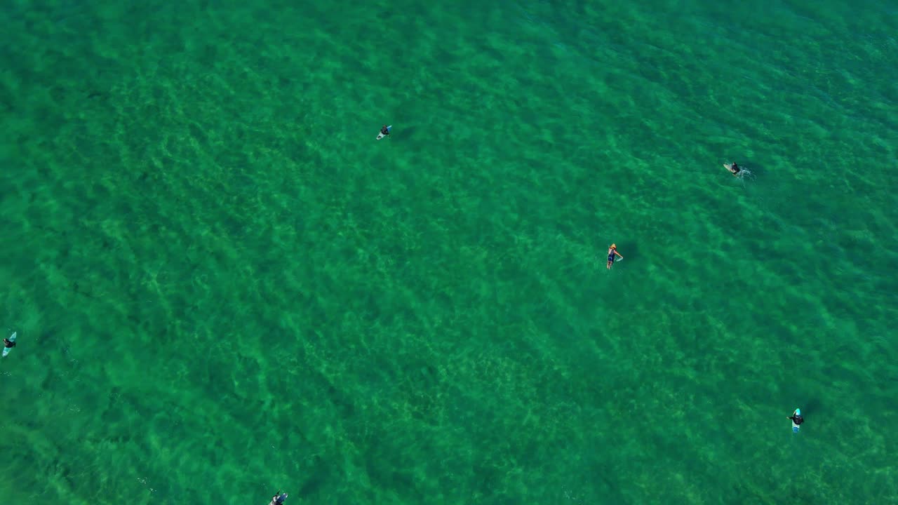 серферы катаются на серфе у сине-зеленой воды океана - пляж кабарита в нсв, австралия