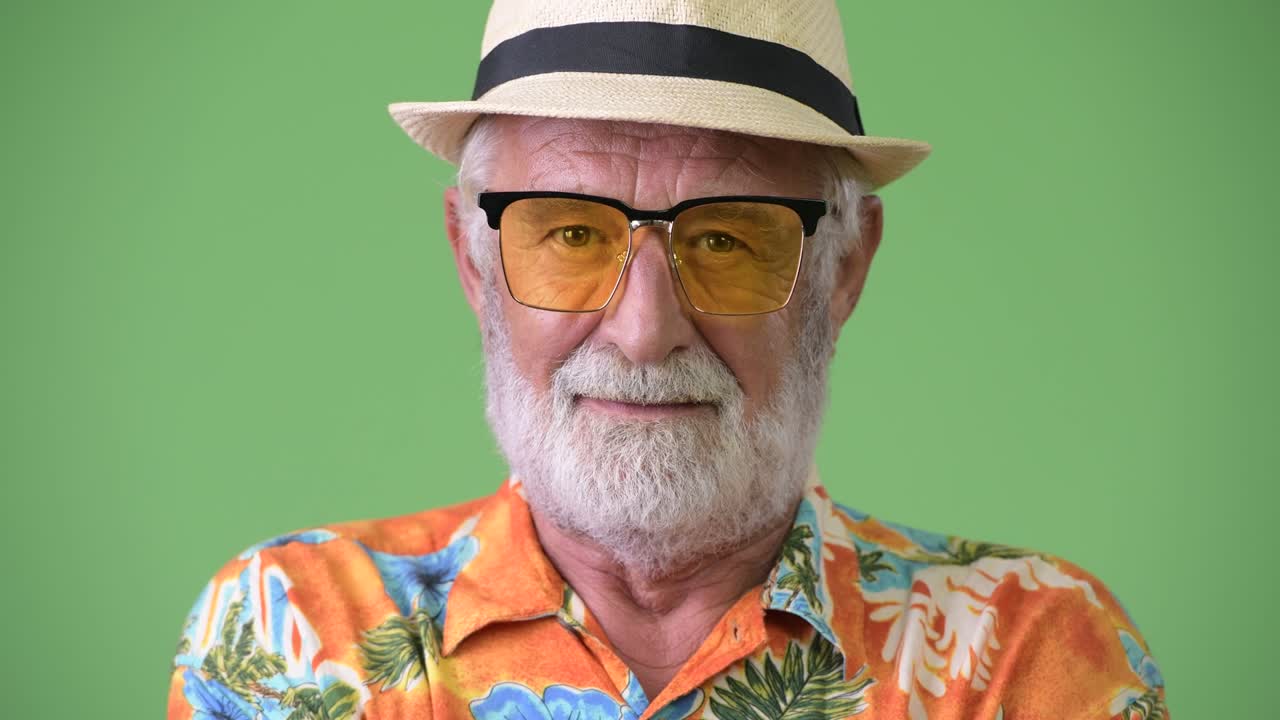 hombre turista barbudo y guapo listo para las vacaciones contra un fondo verde