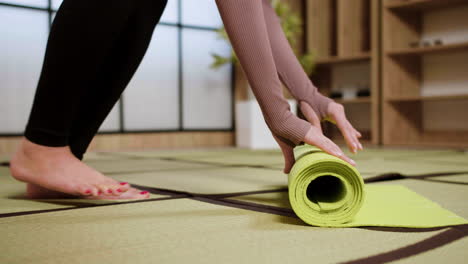 persona que hace rodar el tapete de yoga