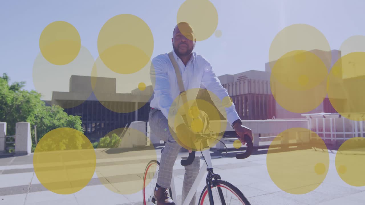 Animação de pontos amarelos sobre empresário afro-americano andando de bicicleta na cidade
