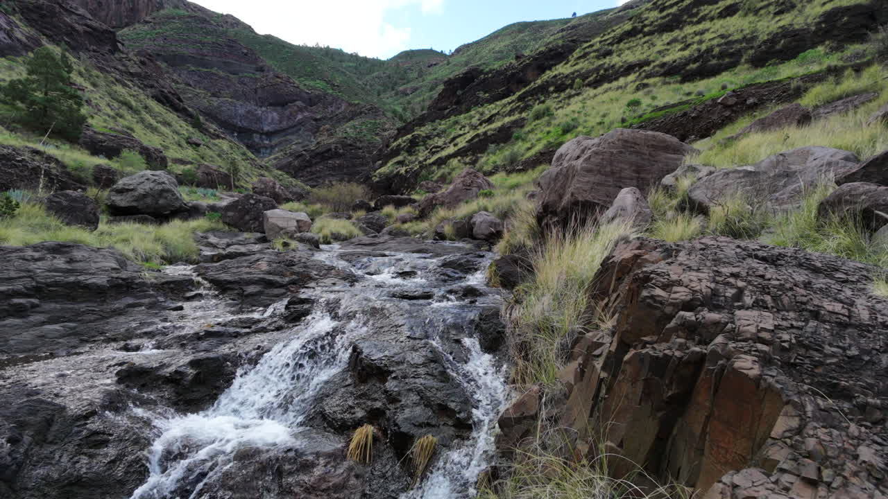 Aliran air jernih mengalir melalui ngarai Risco menuju Charco Azul di Agaete, Gran Canaria
