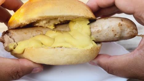 Messy-eating-by-hand-of-Krakauer-sausage-with-bread-and-mustard-Personal-perspective