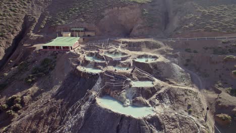 tourists at the hot-spring valley with outdoor mineral pools in termas colina near santiago, chile