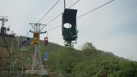 Empty-single-person-ropeways-through-the-Ratnagiri-hills-under-the-cloudy-sky,-Rajgir,-Bihar