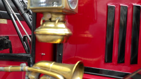 Close-up-shot-of-a-brass-horn-and-a-vintage-lantern-on-an-oldtimer-bus-coach