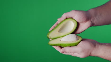 abriendo un aguacate recién cortado a la mitad.