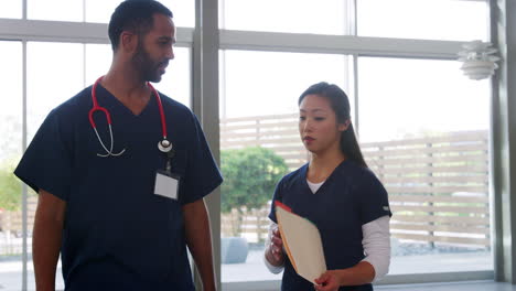 male doctor and female nurse walk to the camera in hospital