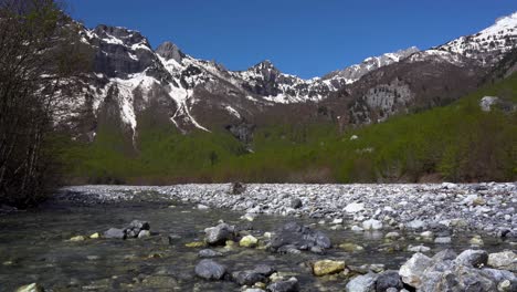 calming panorama, magnificent alpine landscape with snow-capped mountains and stream with crystal clear water