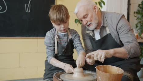 grandfather and grandson making pottery together