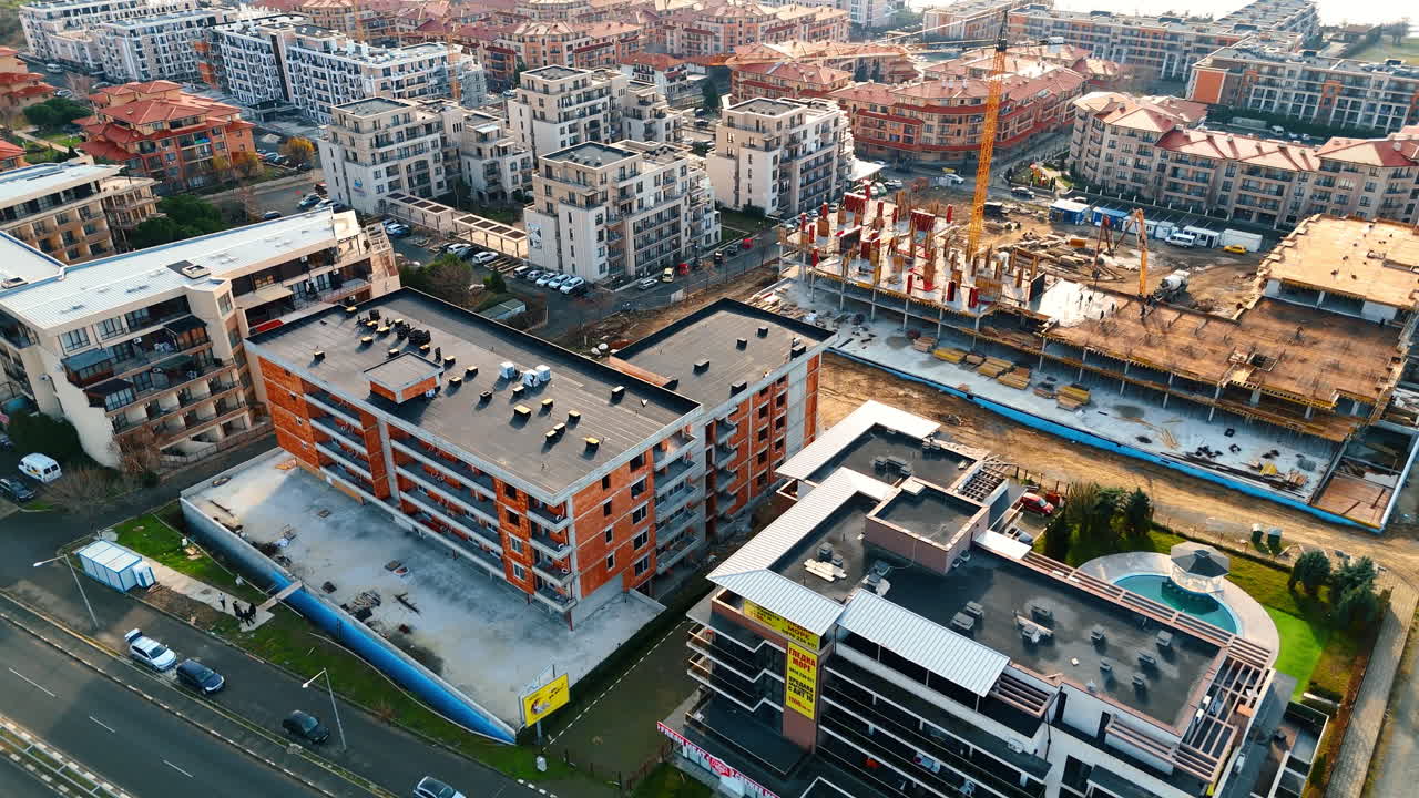 Modern bir yerleşim bölgesinin ve inşaat alanının yüksekten görünümü. Arabaların, modern apartman bloklarının ve vinçli aktif bir şantiyenin kuşbakışı görünümü