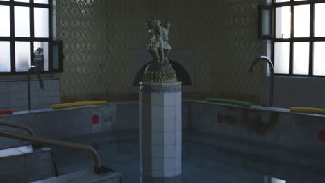 Old-bathtub-pool-with-column-with-sculpture-in-Tskaltubo-spa,-Georgia